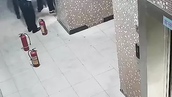 Man Holding Electric Bike Battery In Elevator