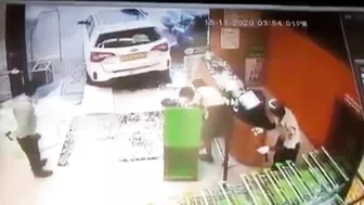 Husband Sitting In Car While Wife Putting Shopping Bags In Trunk