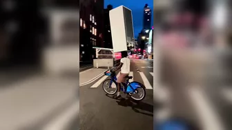 A Cyclist Carries A Refrigerator On His Head