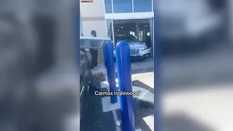 An Angry Customer Drives Past A CarMax Dealership