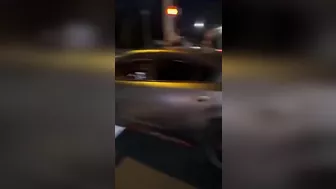 Leaning Out Of The Window While Performing Stunt Driving At An Intersection