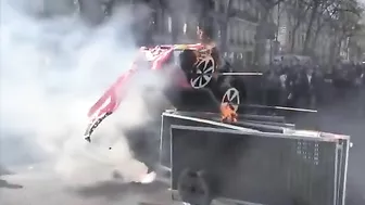 Protesters In Paris Display American Flags And Cardboard Teslas